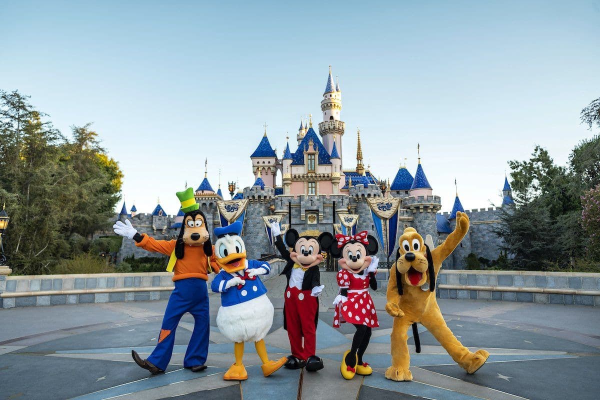 Disney Characters stand in front of a castle at Disneyland.
