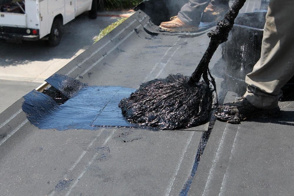 "Hot Mop" roofing is applied to a flat roof.